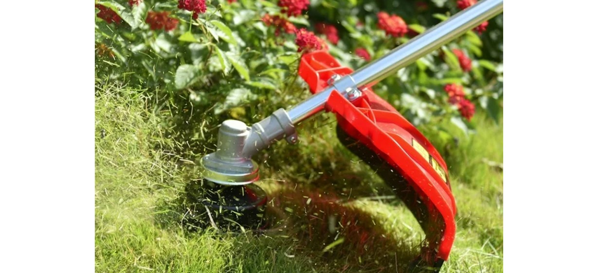 PowerSmart String Trimmer and Brush Cutter in flower garden with red flowers