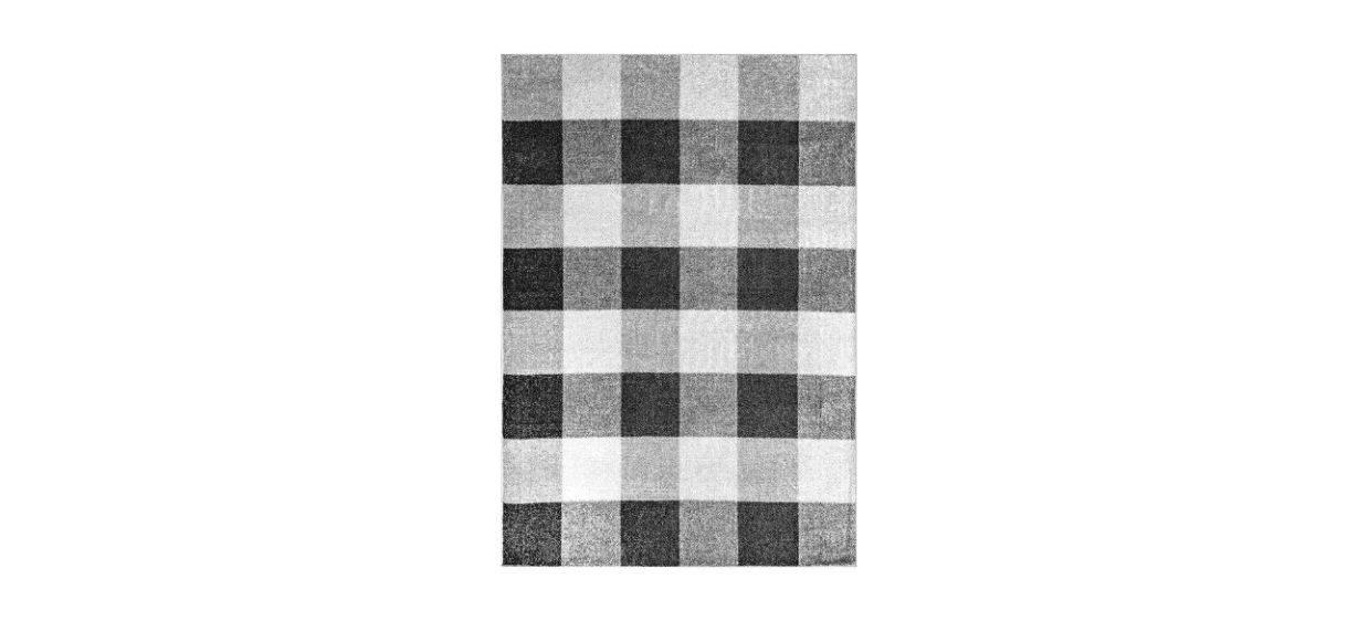 a buffalo plaid area rug, with alternating black, gray and white squares
