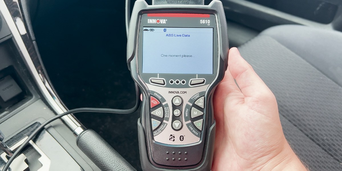 Hand holding Innova Bidirectional Scan Tool inside car Hand holding Innova Bidirectional Scan Tool inside car