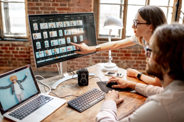 People around a desk looking at a monitor