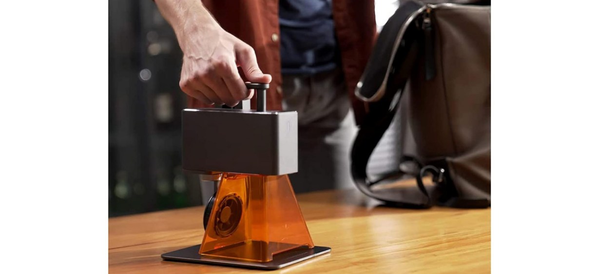 Hand pushing button on  LaserPecker 2 Laser Engraver