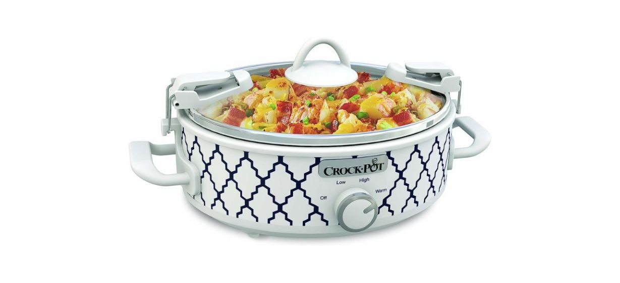 A white crockpot slow cooker with a lid and navy blue designs on it