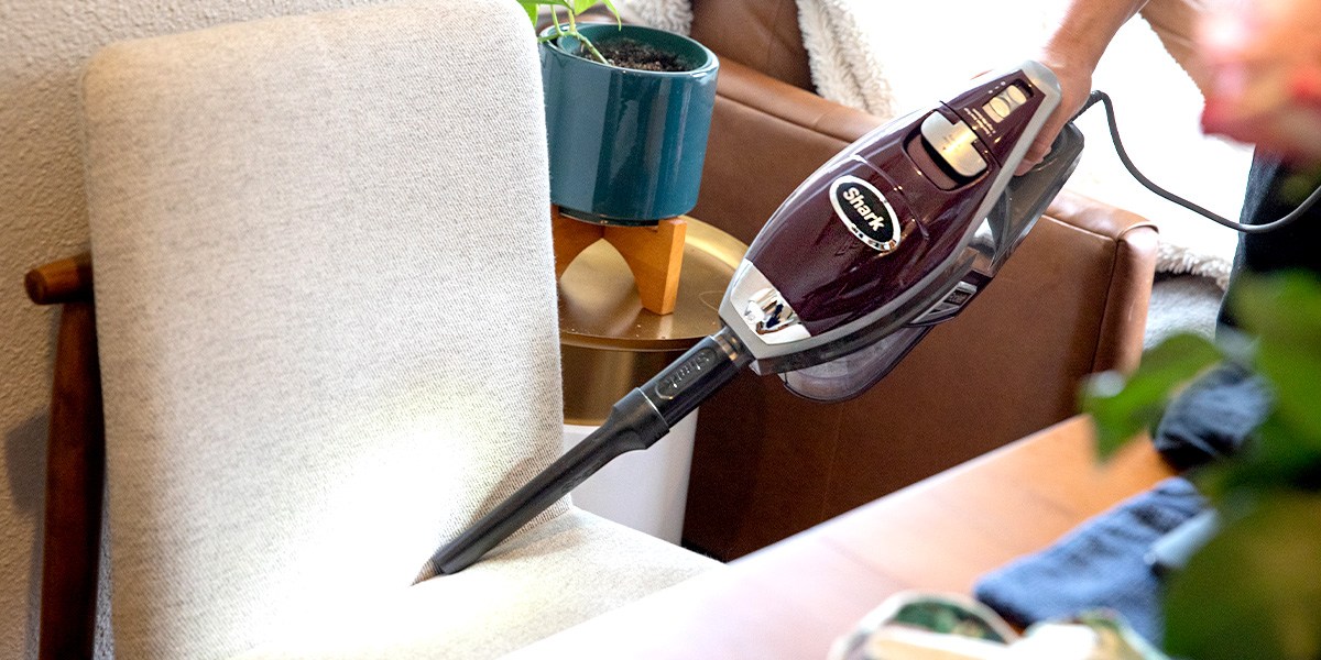Person cleaning chair upholstery with Shark Rocket Pet Vacuum 